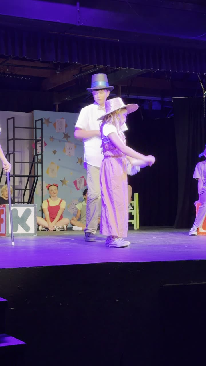 Wynter Pearce centre stage in a pink costume during a musical number