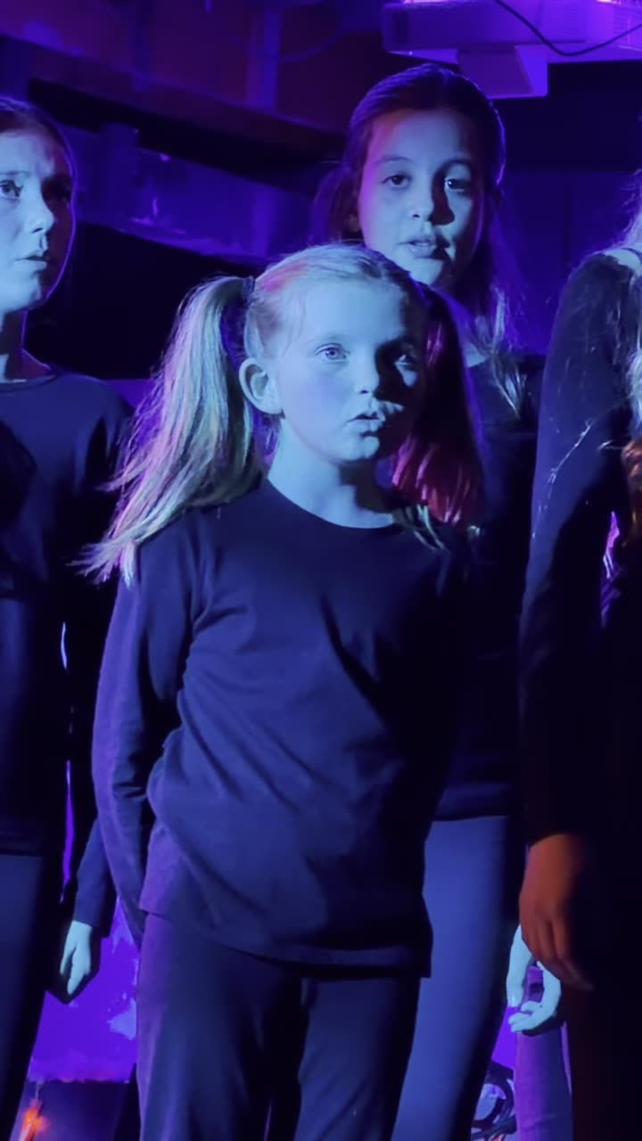 Ensemble singing under blue stage lighting